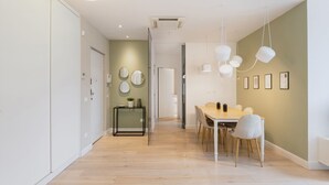 A modern kitchen with a wooden floor, a dining table with chairs, and pendant lights. - Easylife - Precious Pearl in Porta Romana (Milano)