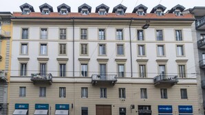 A multi-story building with a symmetrical facade, featuring evenly spaced windows and balconies. - Easylife - Cozy studio apartment in Navigli area (Milano)