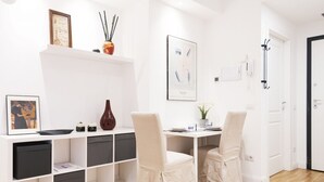 A modern, well-lit room with a white desk, two chairs, a bookshelf, and a door. - Easylife - Bright and charming flat with balcony (Milano)