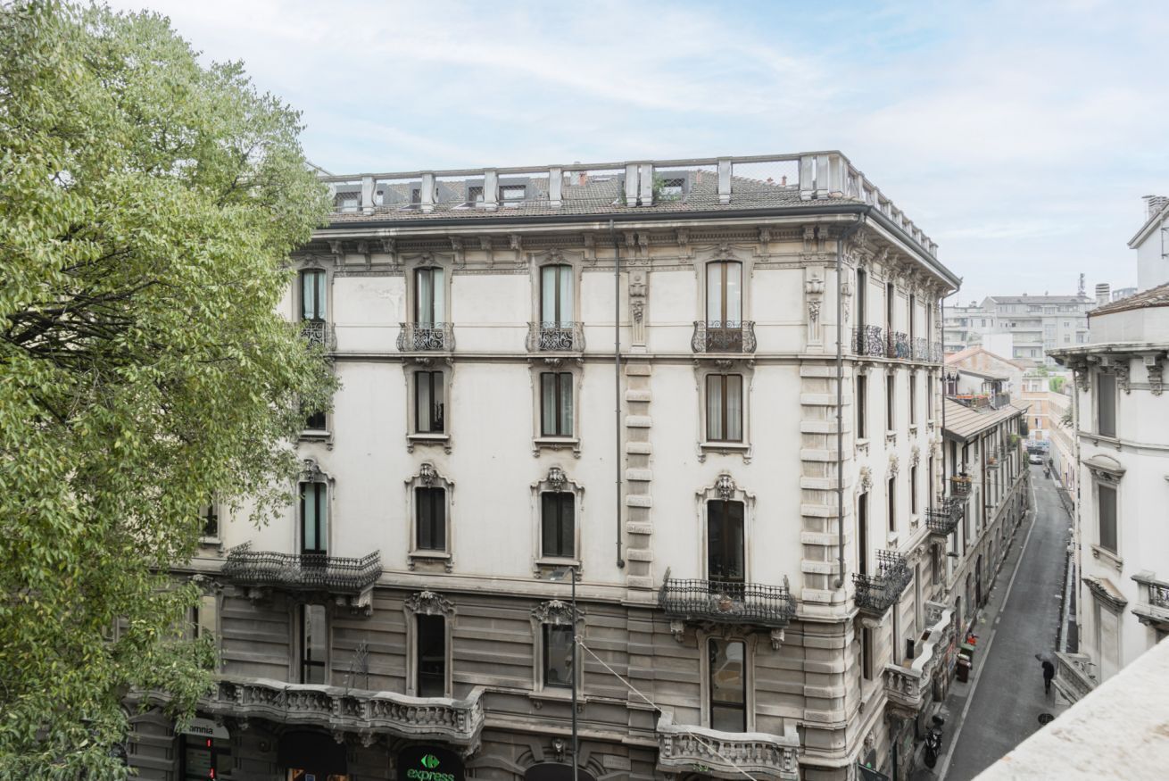 A multi-story building with classical architecture, featuring balconies and a central entrance.
