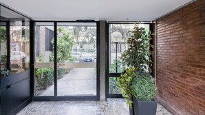 A modern indoor space with large glass doors leading to an outdoor area.
