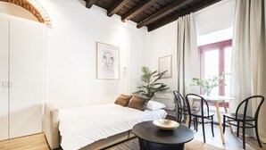 A bedroom with a bed, a round table, chairs, a plant, and artwork on the walls. - Easylife - Soak up the Crisp, Minimal Vibe at a Light-Filled City Oasis (Milano)