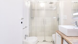 A modern bathroom with a glass-enclosed shower, a white sink, and a bidet. - Easylife - Soak up the Crisp, Minimal Vibe at a Light-Filled City Oasis (Milano)