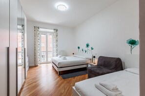 A modern bedroom with a bed, a chair, and a desk.