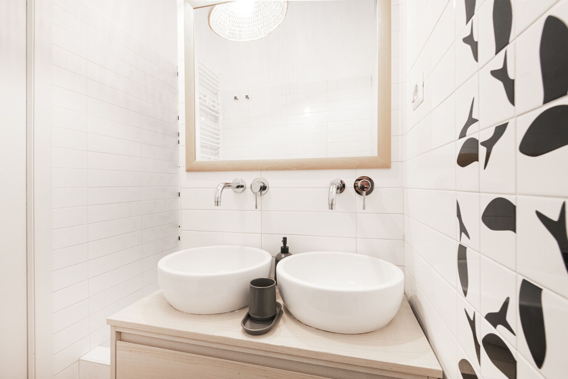 Une salle de bain avec deux lavabos, un miroir et une douche.