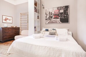 A neatly arranged bedroom with a bed, a wooden wardrobe, a bookshelf, and a framed picture on the wall. - Easylife - Oasis of comfort&style in Porta Romana (Milano)