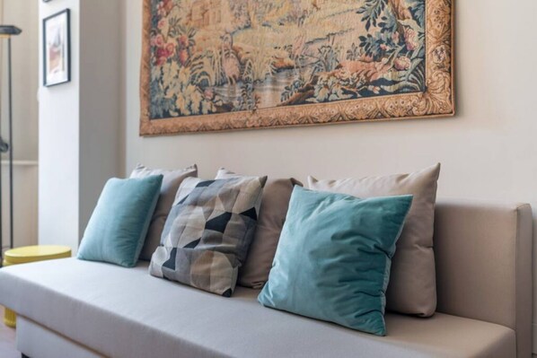 A sofa with four cushions in a living room.