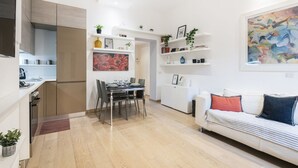A modern apartment with a dining area, kitchen, and living space.