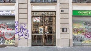 Eine Gebäudefassade mit einem Metallgitter, Graffiti an den Wänden und einem Schild des Geschäfts Goody's.
