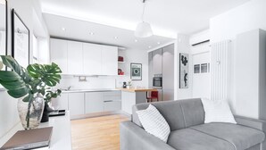 Un salon moderne avec un canapé gris, une table basse et une plante.