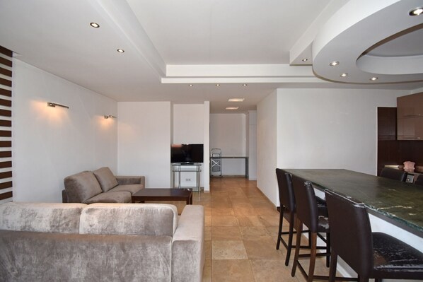 Departamento Deluxe | Área de sala de estar | Smart TV de 100 cm con canales por cable y películas con cargo 
