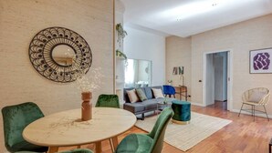 A modern living room with a round table, green chairs, a sofa, and a large mirror. - Easylife -Amazing flat Repubblica Central Station (Milano)