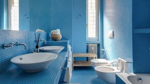 A bathroom with blue tiled walls, two sinks, a bathtub, and a toilet. - Easylife -Amazing flat Repubblica Central Station (Milano)