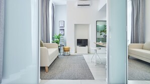 A modern living room with a sofa, a coffee table, a TV, and a small side table.