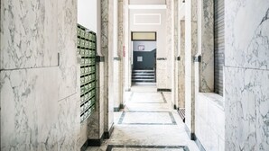 A marble-floored hallway with a staircase leading to a room with a window. - Easylife - Beautiful flat in Porta Romana (Milano)