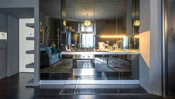 A modern kitchen with a central island, stainless steel appliances, and pendant lighting.