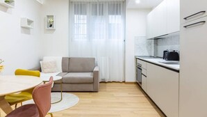 A modern kitchen with white cabinets, a marble countertop, and a built-in oven. - Easylife - Cozy two-room apartment in Porta Venezia area (Milano)