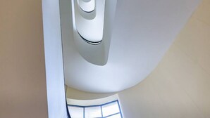 A modern interior with a curved ceiling and a large window. - Easylife - Cozy two-room apartment in Porta Venezia area (Milano)