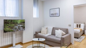 A modern living room with a sofa, a coffee table, a TV, and a framed picture on the wall.