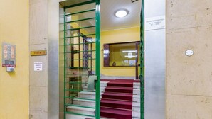 Eine Treppe mit roten Teppichstufen, die zu einer Zwischenebene führen.