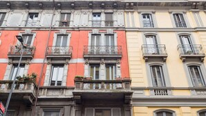 A row of multi-story buildings with balconies, each with a different color facade. - Easylife - Golden Navy Design apt Pta Venezia (Milano)