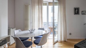 A dining area with a round table, chairs, and a buffet bowl. - Easylife - Sophisticated studio with balcony in the heart of Porta Venezia (Milano)