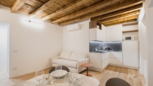 Une cuisine moderne avec des armoires blanches, un four encastré et un four à micro-ondes.