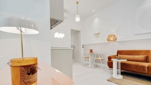 Una sala de estar moderna con una mesa redonda, un sofá y una lámpara.