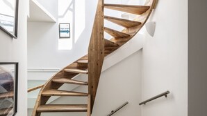 A wooden spiral staircase in a modern interior with white walls and a sign indicating a 'Magic Terrace'. - Easylife - Double Suite (Milano)