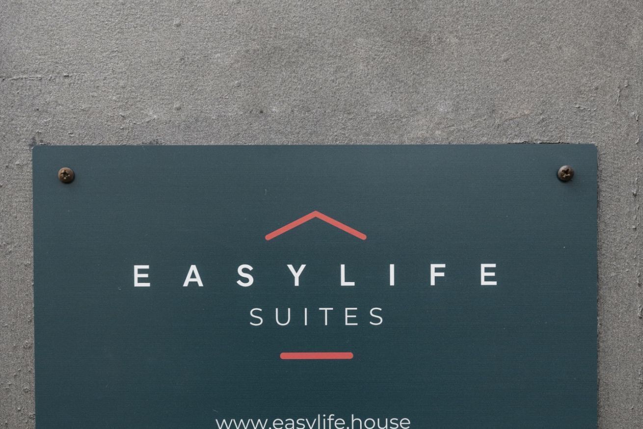 A sign for EasyLife Suites with a simple design and the website URL.