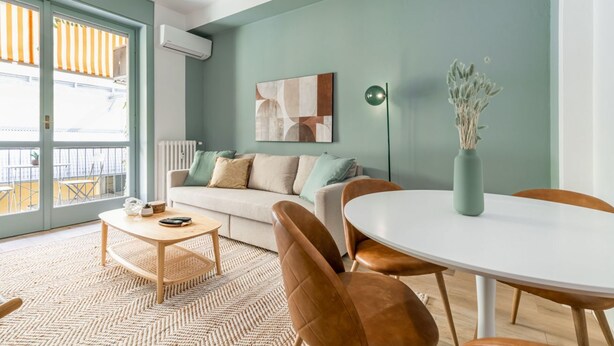 A modern living room with a sofa, coffee table, and dining table. - Easylife - Warm gem in Porta Venezia (Milano)