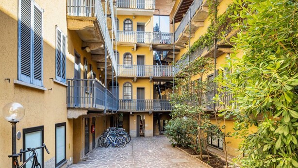 A narrow alleyway with a row of yellow buildings, each with balconies and shutters. - Easylife - Romantic flat in Darsena (Navigli) (Milano)