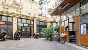 Um pátio com uma loja Zolfo, motocicletas estacionadas e bicicletas.