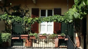 A building with a balcony, a door, and windows with shutters. - Easylife - Naviglio, sweet dreams in the heart of the fun (Milano)