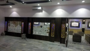 A reception area with a modern design, featuring a large wall with circular patterns and a digital display.