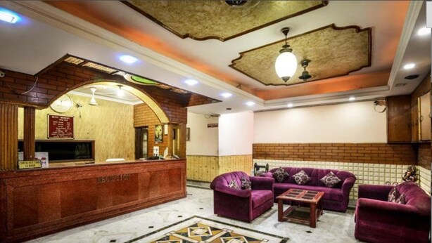 A reception area with a wooden reception desk, purple sofas, and a patterned floor.