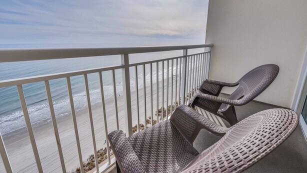A balcony with wicker furniture overlooking a beach. - Newly Updated, Beachside  Spectacular at Bay Watch (North Myrtle Beach)