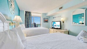Una camera d'albergo con due letti, televisione, scrivania e finestra con vista.