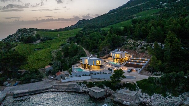 A modern villa with a pool, situated on a hillside overlooking a body of water. - Villa Luce by Villas Guide (Pijavicino)