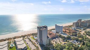 Ein Küstenhotel mit Pool, Strandblick und mehreren Gebäuden.