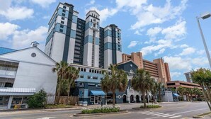 Un hotel de varios pisos con un diseño moderno, que destaca por una torre imponente y una combinación de estilos arquitectónicos.