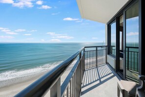 Un balcon avec vue sur l’océan et la plage.