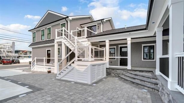 A two-story house with a covered porch and a staircase leading to the upper level.