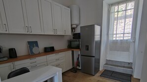 A compact kitchen with white cabinets, a stainless steel refrigerator, a microwave, and a wooden countertop. - APPT F2 RDJ 4/5 PERSONS- ALL COMFORT - QUIET - CLOSE TO THERMAL BATHS  (La Bourboule)