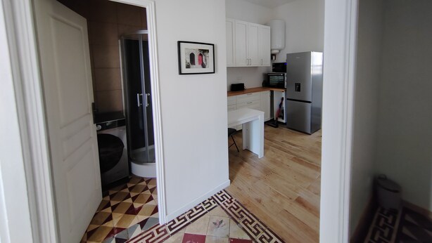 A modern kitchen with white cabinets, a stainless steel refrigerator, and a microwave. - APPT F2 RDJ 4/5 PERSONS- ALL COMFORT - QUIET - CLOSE TO THERMAL BATHS  (La Bourboule)