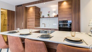Una cucina moderna con isola centrale, mobili in legno e forno integrato.