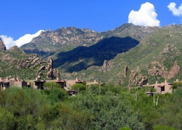 Un paisaje montañoso con edificios en primer plano.