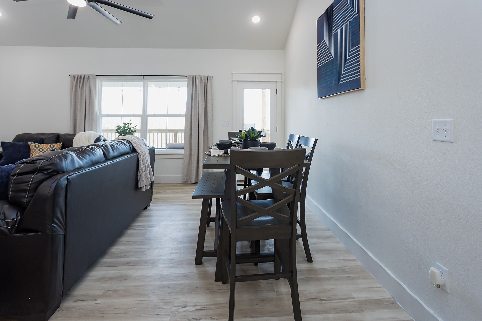 A modern living room with a sofa, dining table, and chairs.