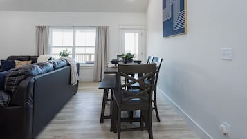 Een moderne woonkamer met een bank, een eettafel en stoelen.