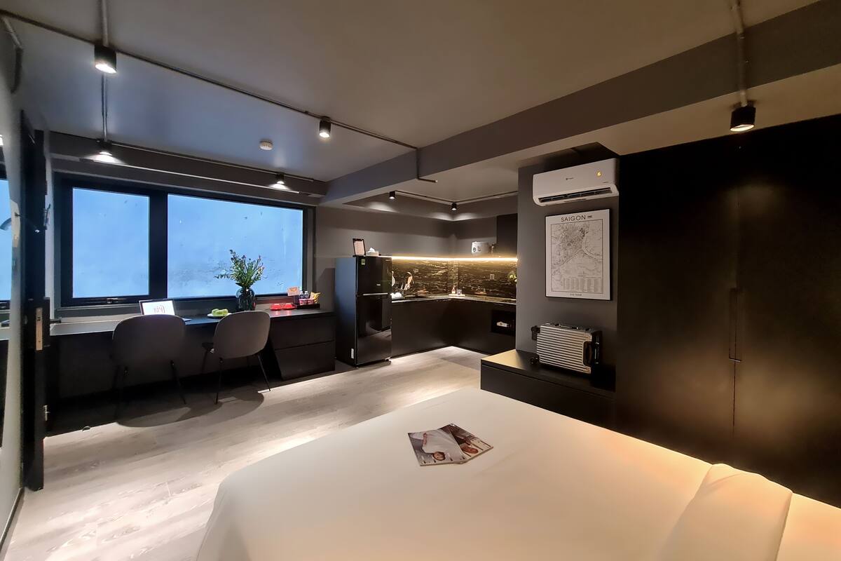 A modern hotel room with a large bed, a desk, and a seating area.